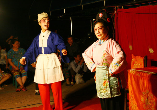 A Huangmei opera is performed by a travelling theater group on an open-air stage in Anqing city, east China's Anhui Province, on August 2, 2009. [CRI]