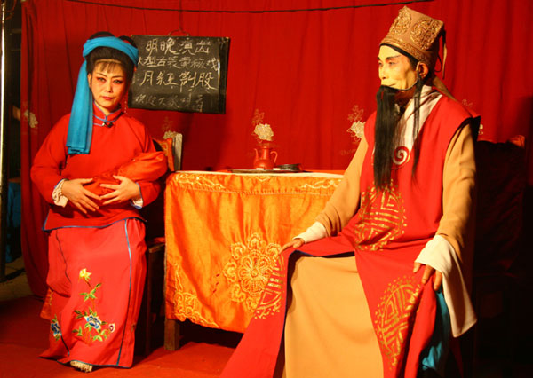 A Huangmei opera is performed by a travelling theater group on an open-air stage in Anqing city, east China's Anhui Province, on August 2, 2009. [CRI]