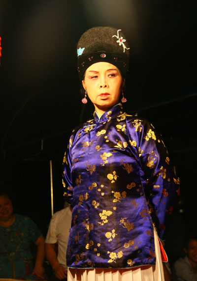 A Huangmei opera is performed by a travelling theater group on an open-air stage in Anqing city, east China's Anhui Province, on August 2, 2009. [CRI]