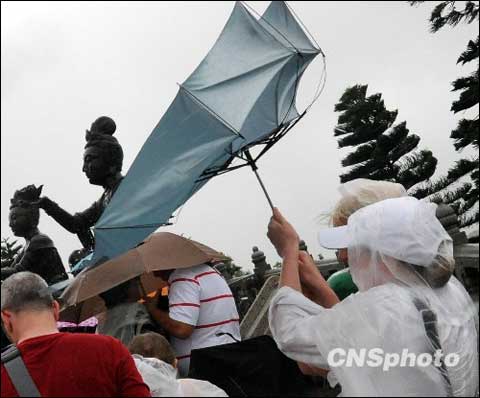 Foreign tourists manage to hold their umbrellas against strong wind in Hong Kong, August 4, 2009 as the tropical storm of 'Goni' hits the city.