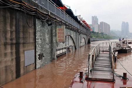 The houses along the Nanbin Road are inundated by rainfalls in southwest China's Chongqing Municipality, August 4, 2009. The continual heavy rainfalls in Chongqing brought about flood over the city, with many lower sections of the riverside streets submerged. [Zhong Guilin/Xinhua]