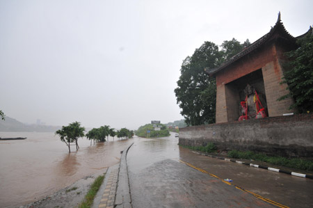 The swollen river approaches a temple on the Binjiang Road in southwest China's Chongqing Municipality, August 4, 2009. The continual heavy rainfalls in Chongqing brought about flood over the city, with many lower sections of the riverside streets submerged. [Zhong Guilin/Xinhua]