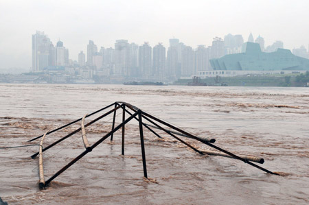 A house under construction is submerged by flood on the Nanbin Road in southwest China's Chongqing Municipality, August 4, 2009. The continual heavy rainfalls in Chongqing brought about flood over the city, with many lower sections of the riverside streets submerged. [Zhong Guilin/Xinhua]