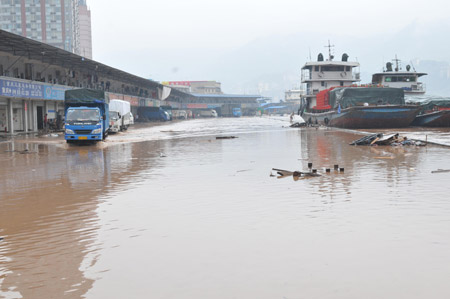 The repository of a logistics company is submerged by flood in southwest China's Chongqing Municipality, August 4, 2009. The continual heavy rainfalls in Chongqing brought about flood over the city, with many lower sections of the riverside streets submerged. [Zhong Guilin/Xinhua]