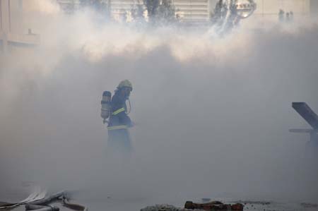 A fire fighter walks at the site where an ammonia gas leak occurred at Chifeng Pharmaceutical Factory in Chifeng City, north China's Inner Mongolia Autonomous Region, on Aug. 5, 2009. A total of 202 people fell ill after the ammonia gas leak here on Wednesday. The leak occurred at 8:40 a.m. when a truck carrying 30 tonnes of liquid ammonia was unloading at the factory of Chifeng Pharmaceutical Group, but was sealed in about 50 minutes, the government said. [Xinhua]