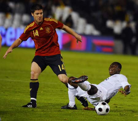 United States' Freddy Adu (R) falls down past Spain's Xabi Alonso as they fight for the ball during their international friendly soccer match at the Sardinero stadium in Santander June 4, 2008.