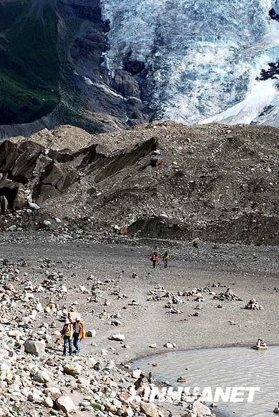 A tourist enjoys the Midui glacier of Tibet on July 31, 2009. Located in Yupu Town, Bomi County, the summit of the glacier is 6,800 meters above sea level and extends about 20 kilometers. The snow line of the glacier mountain is 4,600 meters above sea level. In 2007, local residents opened a Midui glacier travel spot. [Photo: Xinhuanet]