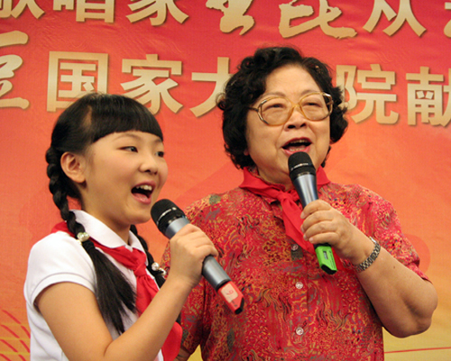 Folk singer Wang Kun(R) sings with her disciple Huang Jiaqi on July 30.