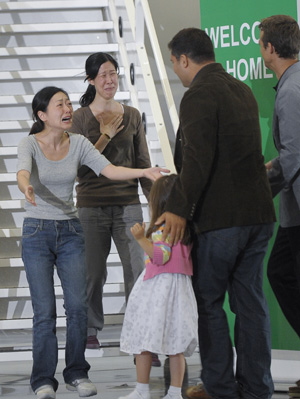 Laura Ling (R, Back) and Euna Lee (1st L), two freed U.S. journalists, are embraced by their family members after arrive at the airport in Burbank, California, August 5, 2009. The two female American journalists who had been freed earlier by the Democratic People's Republic of Korea (DPRK) returned to the United States on Wednesday. [Qi Heng/Xinhua]