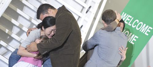 Laura Ling (R, Back) and Euna Lee (1st L), two freed U.S. journalists, are embraced by their family members after arrive at the airport in Burbank, California, August 5, 2009. [Qi Heng/Xinhua]