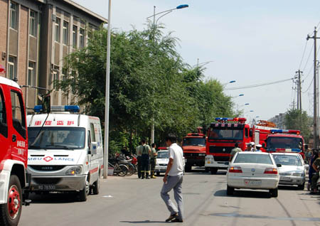 Rescue vehicles await orders near the venue of ammonia leakage accident in Chifeng City of north China's Inner Mongolia Autonomous Region, August 5, 2009.[Xinhua]