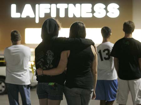 People wait behind police lines outside the LA Fitness gym in Bridgeville, Pennsylvania August 4, 2009 while police investigate a shooting that happened earlier in the evening. At least five people, including the gunman, were shot and killed during a shooting spree at the fitness center near Pittsburgh, according to media reports on Tuesday.[Xinhua/Reuters]