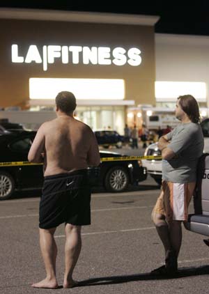 Men wait behind police lines outside the LA Fitness gym in Bridgeville, Pennsylvania August 4, 2009, while police investigate a shooting that happened earlier in the evening.[Xinhua/Reuters]