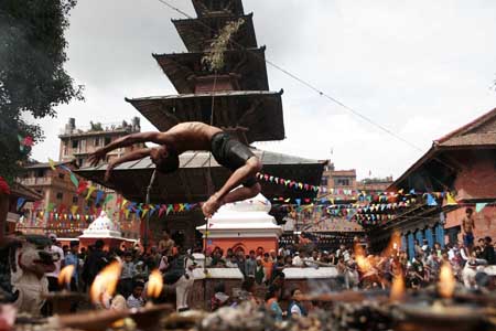 A boy jumps into water at Kumbheswar Temple pond to take a holy dip during the Janaipurnima festival in Lalitpur District of Nepal, Aug. 5, 2009.[Bimal Gautam/Xinhua]