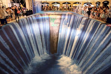 Models walk on a three dimensional visual effect painting at Meilongzhen plaza in Shanghai, east China, Aug. 5, 2009. The 3D painting with the theme of the Shanghai World Expo is made by Edgar Müller. [Xinhua]