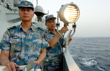 Chinese navy soldiers aboard the Zhoushan missile frigate say hello via light signal to Saudi Arab's Abha missile frigate on the Gulf of Aden, Aug. 4, 2009. Two frigates and a supply ship from the Chinese navy is on their escort mission to fend off Somali pirates. [Xinhua]