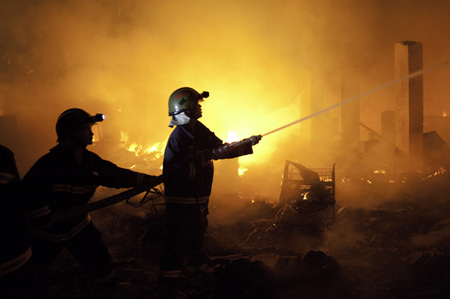 Firefighters try to extinguish a fire at the Xiangnan Furniture Factory in Wuhou District of Chengdu, southwest China's Sichuan Province, on Aug. 5, 2009. A big fire broke out here on Wednesday night and was extinguished around midnight on the same day after 130 firefighters and 20 fire engines were dispatched to the scene. No casualties have been reported so far and the cause of the fire is under investigation. [Xinhua]