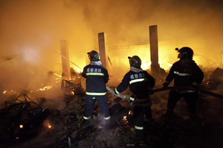 Firefighters try to extinguish a fire at the Xiangnan Furniture Factory in Wuhou District of Chengdu, southwest China's Sichuan Province, on Aug. 5, 2009. [Xinhua]