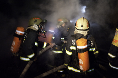 Firefighters try to extinguish a fire at the Xiangnan Furniture Factory in Wuhou District of Chengdu, southwest China's Sichuan Province, on Aug. 5, 2009. [Xinhua]