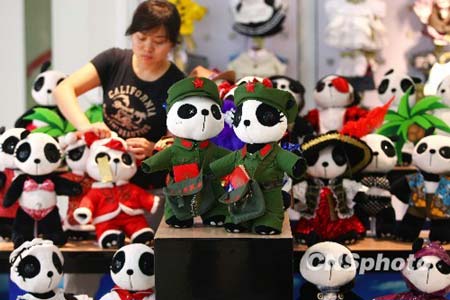 A shop assistant dresses up panda dolls in Beijing on Monday, August 3, 2009. [CNSphoto]