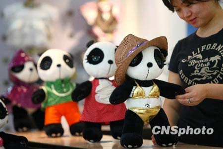 A shop assistant dresses up panda dolls in Beijing on Monday, August 3, 2009.[CNSphoto]