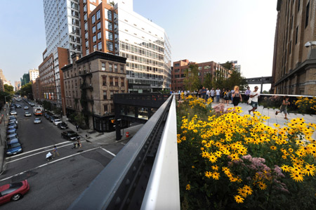 People take a walk at the High Line Park in Manhattan, New York, the United States, on Aug. 4, 2009. The first phase of the High Line Park, established on the base of western Manhattan's abandoned cargo railway with a stretch of about 2.5 km covering more than 20 street sections, was open to public recently. The High Line Park offers people here a pleasant place to approach nature in the forest of skyscrapers.[Xinhua]