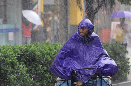 A local rides a bicycle in the rain in Guangzhou, capital of south China's Guangdong Province, on Aug. 5, 2009. The tropical storm Goni landed at a speed of 83 km per hour early Wednesday morning in Taishan of Guangdong Province, according to local meteorological station. 