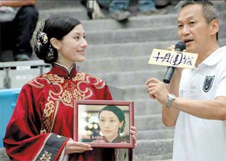 Film director Teddy Chan makes a gift to actress Michelle Reis at the closing ceremony of the shooting of the film 'Bodyguards and Assassins.' The film marks actress Reis' return to the screen after her marriage to business tycoon Julian Hui last year.