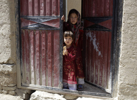 Children look out of a doorway in Kabul, August 6, 2009.[Xinhua/Reuters]