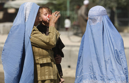 An Afghan woman feeds her baby in Kabul, August 6, 2009. [Xinhua/Reuters]