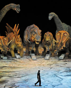 A man walks past some of the dinosaurs featuring in the 'Walking With Dinosaurs' arena spectacular at the O2 Arena in London, Wednesday Aug. 5, 2009. [Xinhua/Reuters] 