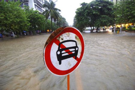 A traffic sign showing the flooded street forbids vehicles to pass through in Haikou, capital of south China's Hainan Province, Aug. 6, 2009. The tropical storm Goni, which landed early Wednesday morning in Taishan of south China's Guangdong Province, has brought heavy rainfall to Haikou, flooding all the main streets of the city. [Zhao Yingquan/Xinhua]