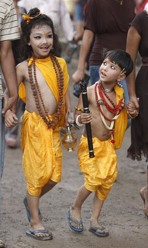 Boys dressed up as holy men take part in the Gaijatra festival parade in Kathmandu August 6, 2009. Family members who have lost a kin dressed up as deities and cows in remembrance of their loved ones during the festival. The cow is regarded as a holy animal that helps the departed souls reach heaven.[Xinhua/Reuters]