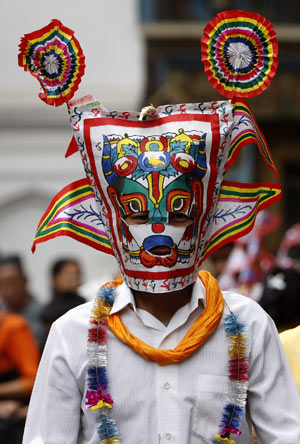 A man wearing a traditional mask takes part in the Gaijatra festival parade in Kathmandu August 6, 2009. [Xinhua/Reuters]