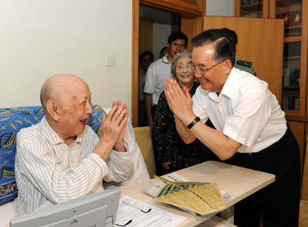 Chinese Premier Wen Jiabao(R) talks with Qian Xuesen, a renowned scientist and founder of China's space technology, during his visit to Qian in Beijing, capital of China, on Aug. 6, 2009. Chinese Premier Wen Jiabao on Thursday personally conveyed National Day greetings to elderly scientists who have made prominent contributions to atomic and medical research. [Xinhua] 