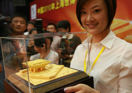 An employee presents a gold model of 'China Pavilion' in Shanghai, east China, on August 6, 2009. The first gold model of 'China Pavilion' of Shanghai 2010 World Expo was issued here on Thursday.[Xinhua]