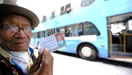 An elder of Tibetan ethnic group shows a free card at a bus station in Lhasa, capital of southwest China's Tibet Autonomous Region, Aug. 5, 2009. The elder people over 60 years old in Lhasa can take bus freely since this April. Nearly 8,000 elders have got the free card by now. [Xinhua]