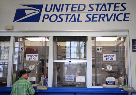 A customer takes mailing services at a post office in New York, the United States, August 6, 2009. The U.S. Postal Service (USPS) has been struggling with a sharp decline in mail volume as people and businesses switch to e-mail both for personal cotact and bill paying. USPS is planning to close several hundreds of post offices, the lastes cost-cutting step for its scrambling to deal with a projected 7 billion USD deficit this fiscal year and larger losses in 2010.[Xinhua]