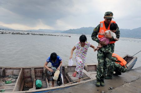 Members of local police help fishermen evacuate in Fuzhou, capital of southeast China's Fujian Province, on Aug. 6, 2009. The eye of Typhoon Morakot was located at 840 kilometers east of Fuzhou City as of 11 a.m. Thursday. 