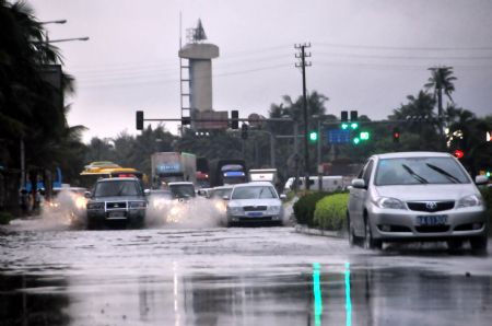 Vehicles drive past a flooded street in Haikou, capital of south China's Hainan Province, Aug. 6, 2009. The tropical storm Goni, which landed early Wednesday morning in Taishan of south China's Guangdong Province, has brought heavy rainfall to Haikou, flooding all the main streets of the city. [Deng Jia/Xinhua]