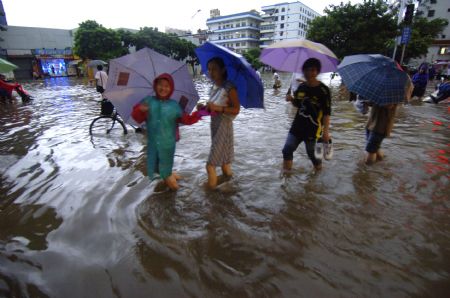 People paddle on a flooded street in Haikou, capital of south China's Hainan Province, Aug. 6, 2009. The tropical storm Goni, which landed early Wednesday morning in Taishan of south China's Guangdong Province, has brought heavy rainfall to Haikou, flooding all the main streets of the city. [Zhao Yingquan/Xinhua]