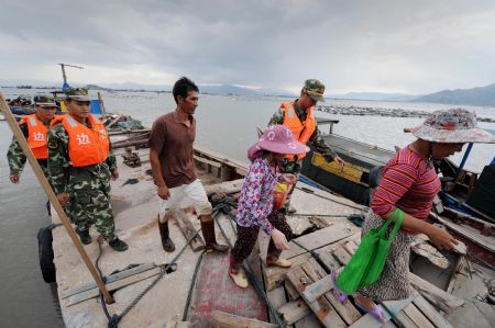 Members of local police help fishermen evacuate to the shore in Fuzhou, capital of southeast China's Fujian Province, on Aug. 6, 2009. The eye of Typhoon Morakot was located at 840 kilometers east of Fuzhou City as of 11 a.m. Thursday. 