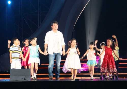 Popular star Emil Chau performs with children. [By Ni Yuanjin/China.org.cn]
