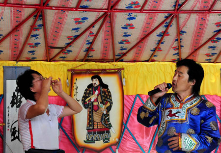 A singer sings a song for tourists in a Mongolian yurt in Horqin Youyi Qianqi, north China's Inner Mongolia Autonomous Region, on Aug. 6, 2009. (Xinhua/Wang Song) 
