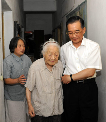 Chinese Premier Wen Jiabao(1st, R) supports He Zehui(C), a renowned Chinese physicist, during his visit to He in Beijing, capital of China, on Aug. 6, 2009.