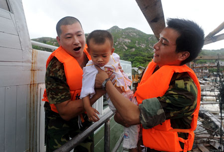 Rescuers evacuate a baby to the safe place in Ningde City, southeast China's Fujian Province, on Aug. 7, 2009.[Jiang Kehong/Xinhua]