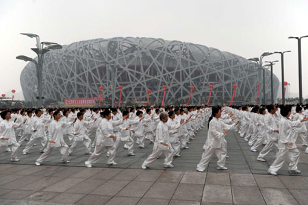 People take part in an attempt to break the Guinness world record for the largest number of people practising Taiji in multiple locations, outside the National Olympic Stadium, also known as the Bird's Nest, to mark the one-year anniversary of the Beijing Olympic Games in Beijing August 8, 2009. [Xinhua]