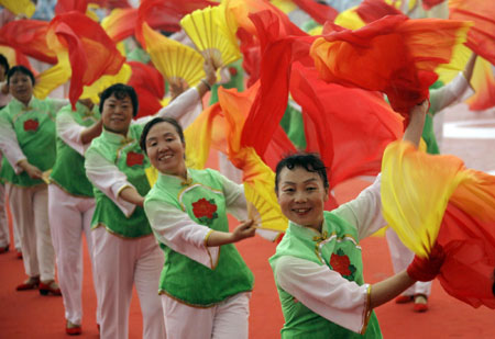 Residents perform with coloured fans to mark the one-year anniversary since the Beijing Olympic Games, outside the National Olympic Stadium, also known as the Bird's Nest, in Beijing August 8, 2009. [China Daily via Agencies]