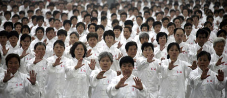 People take part in an attempt to break the Guinness world record for the largest number of people practising Taiji in multiple locations, outside the National Olympic Stadium, also known as the Bird's Nest, to mark the one-year anniversary of the Beijing Olympic Games in Beijing August 8, 2009. [China Daily via Agencies]