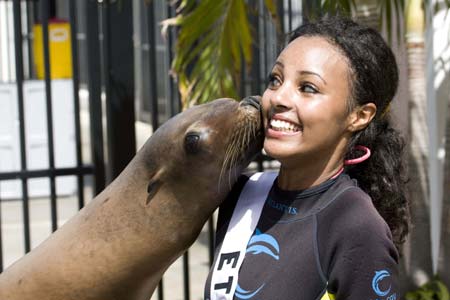 Melat Yante, Miss Ethiopia 2009, gets a kiss from Cassie the Sea Lion while in Dolphin Cay at ATLANTIS, Paradise Island, Bahamas, August 6, 2009. The 2009 Miss Universe competition which will be presented on August 23, 2009. [Xinhua/Reuters]